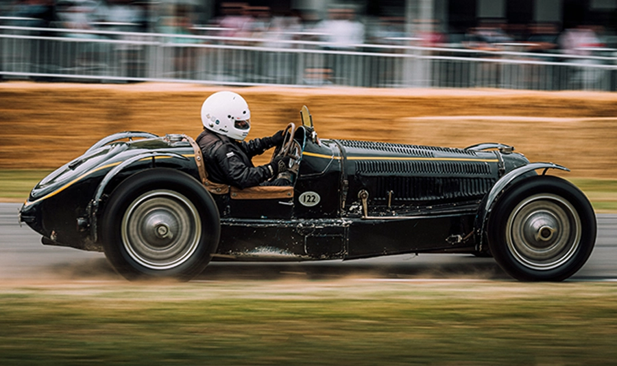 Un gentleman driver au volant d'une voiture de collection lors d'une course automobile de prestige - Photo de George Bale