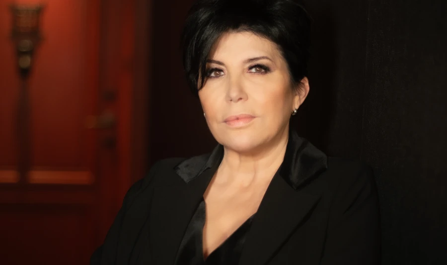 Portrait de la chanteuse Liane Foly vêtue d'une veste noire en velours, le regard posé vers l'objectif.